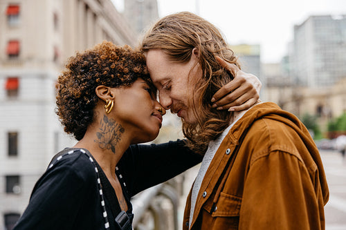 Intimate moment of affection on city streets with stylish couple
