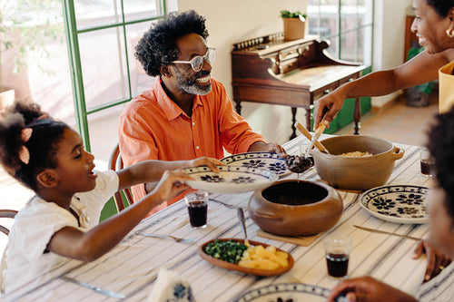 Happy Brazilian family eating traditional cuisine together at home