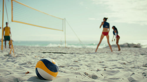 Beach volleyball rally during a championship match on a sunny beach