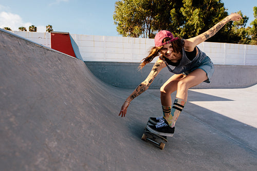 Woman practising skateboarding at skate park