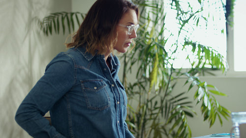 Business professional reviews documents and types on her laptop