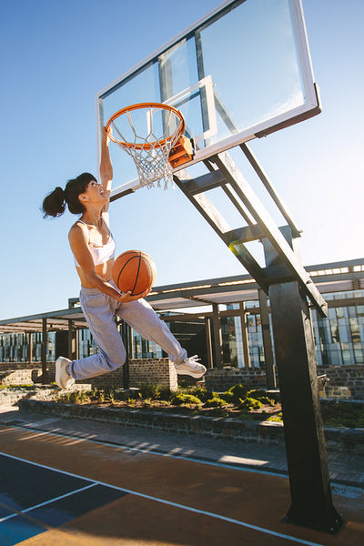 Street basket player making slam dunk