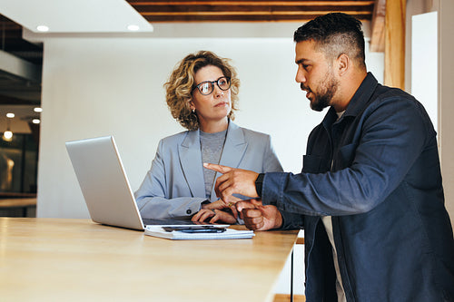 Colleagues discussing a business project in an office