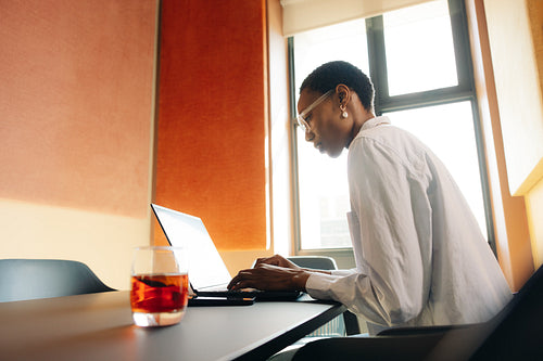 Focused professional working on laptop in contemporary office environment