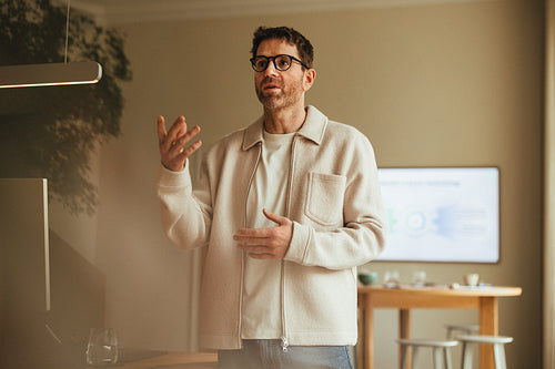 Business man gives a presentation in the office beside a screen