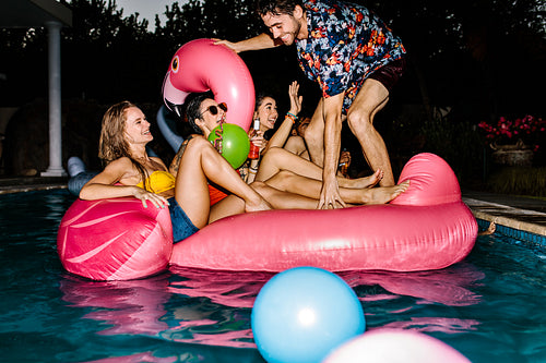 Group of happy friends partying in a swimming pool