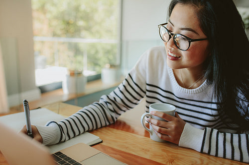 Girl studying at home with laptop on table