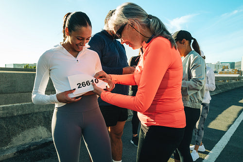 Friends preparing for a community running event outdoors