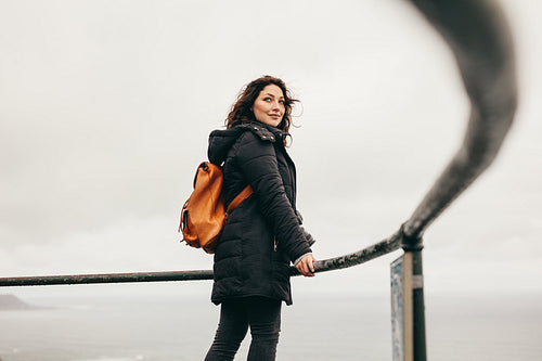 Traveling woman standing at the railing on mountain top