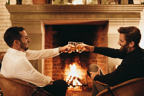 Male best friends making a toast with whiskey glasses