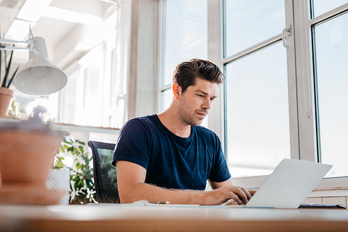 Young male executive working on laptop