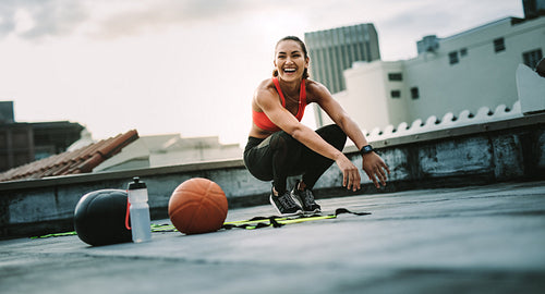 Happy fitness woman training on rooftop in the morning