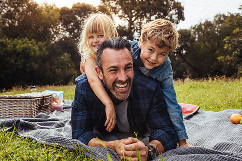 Children playing with their father on picnic
