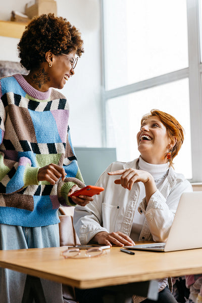Freelance colleagues laughing in a sunny co-working space