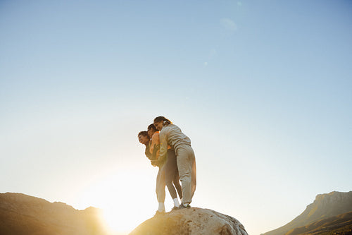 Friends embracing on a rocky hill
