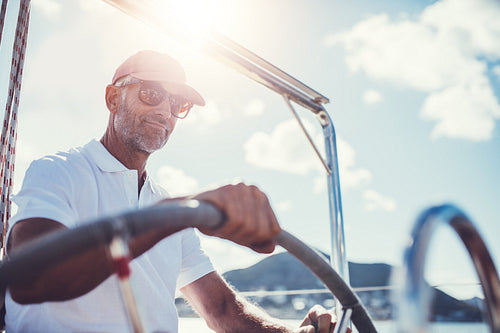 Retired active senior confidently steering his boat