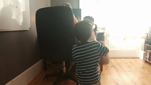 Work life balance with kids: Working mom receiving a visit from her children in her home office