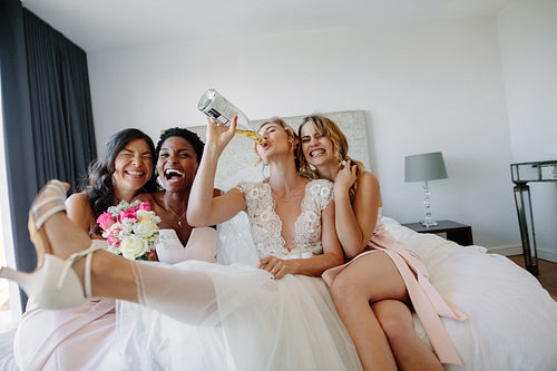 Bride and bridesmaids having fun before wedding