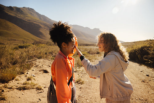 Two women applying sunscreen outdoors