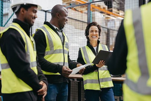 Cheerful woman having a meeting with her colleagues in a warehouse