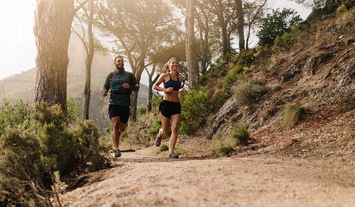Young sporty couple running in the mountains