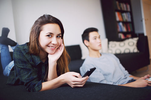 Attractive woman with young man in background at home