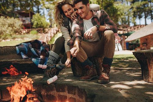 Couple having roasted sweets on camping