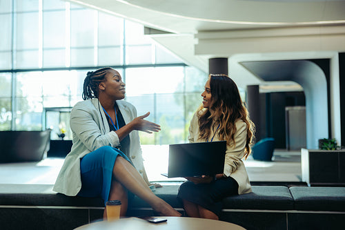 Female coworkers engaging in a productive discussion at the office