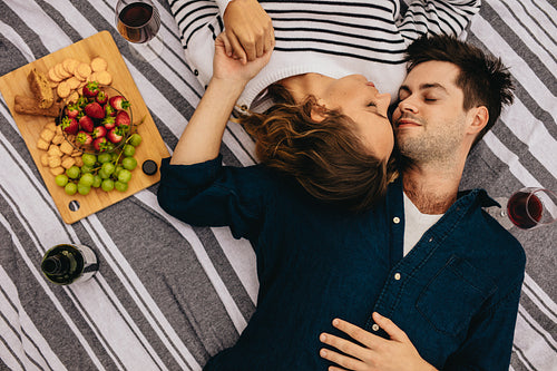 Romantic couple on date lying on floor with heads together