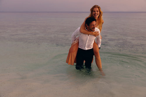 Happy couple having an elopement wedding on an island at sunset