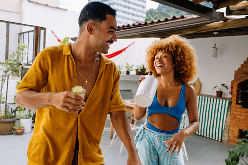 Friends laughing and enjoying drinks on a sunny day in Rio de Janeiro