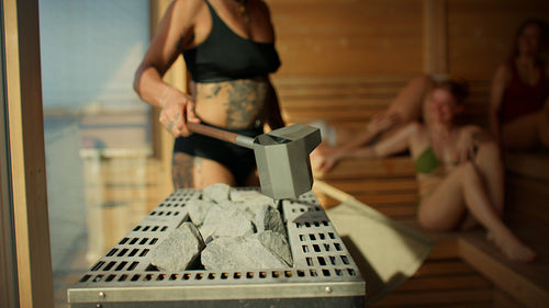 The sauna session shows a woman pouring water during an aufguss ritual