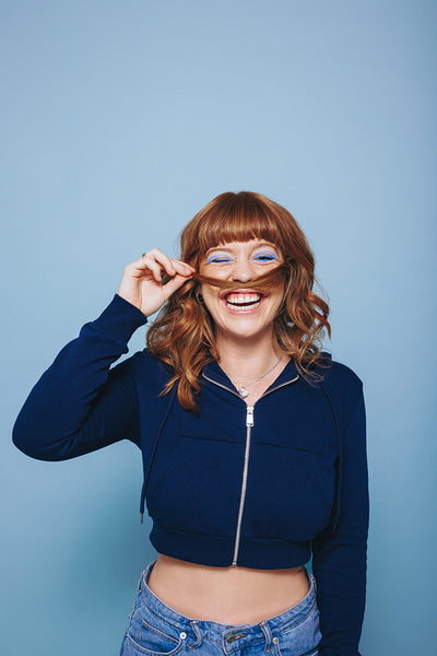 Playful woman making a moustache with her hair