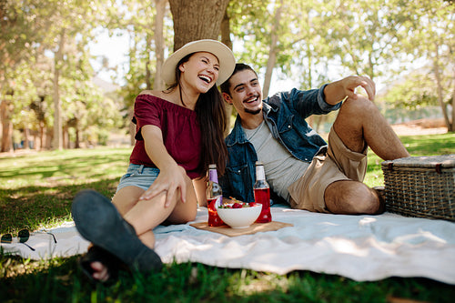 Cheerful couple having a picnic at city park