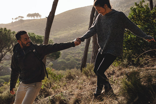 Couple of hikers walking downhill in the countryside