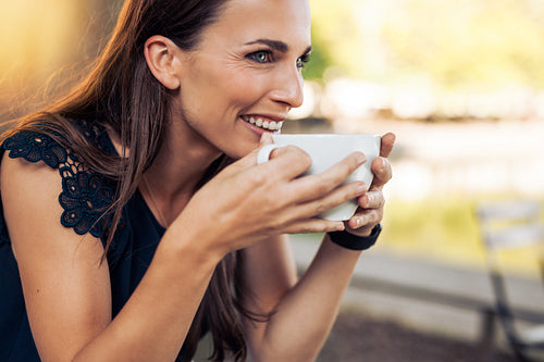 Young woman drinking coffee at cafe