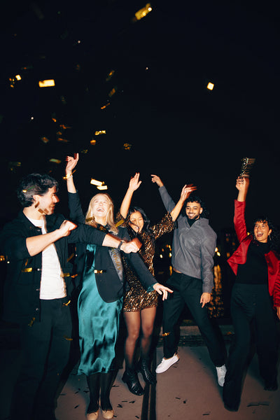 Group of friends celebrating with confetti during a festive night event