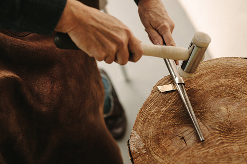 Goldsmilth making a ring in workshop