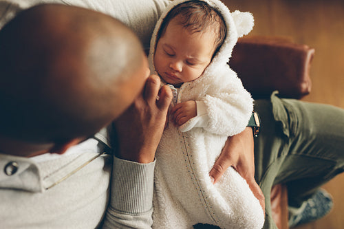 Little baby boy sleeping in his father's arms