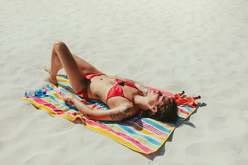 Woman in bikini sunbathing on beach