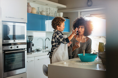 Happy mother and son having fun cooking in kitchen