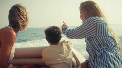 Grandmother, parent and child on a boat expedition searching for dolphins