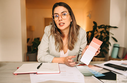 Creative interior designer holding a colour palette on a video c