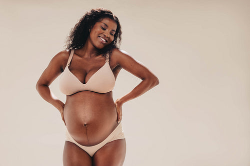 Black mom-to-be celebrating her pregnancy body in a studio