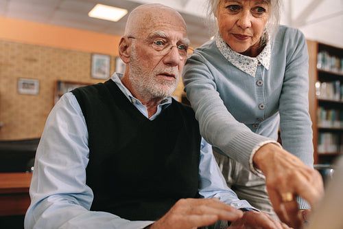 Senior man and woman looking at a computer screen