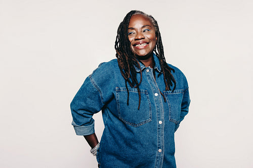 Woman with dreadlocks looking away with a smile in a studio