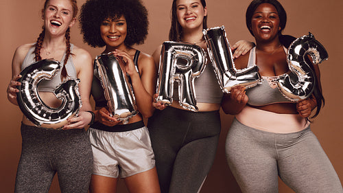 Diverse group of women with girl word in balloon letters