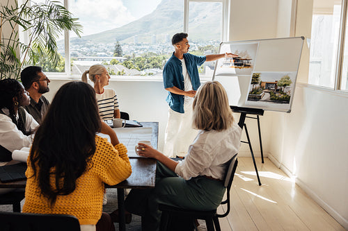 Architect demonstrating project designs to a team in a modern office environment
