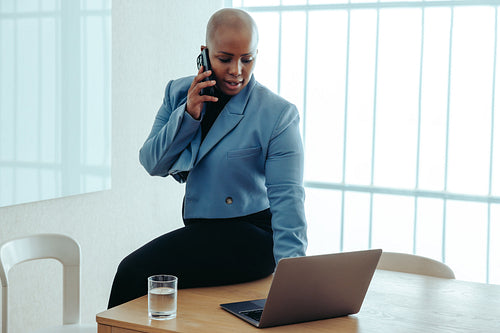 African-American businesswoman balancing work on her smartphone and laptop with ease