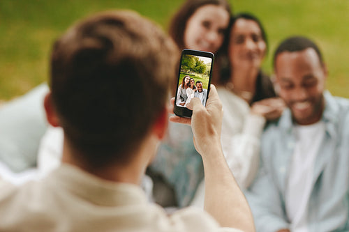 Man photographing his friends at park